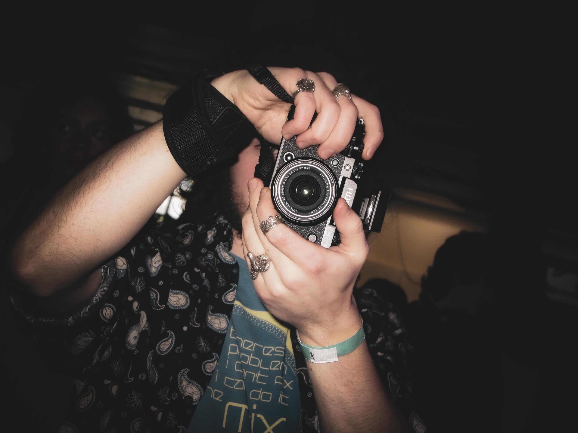 figure holding camera in infront of face, pointed at viewer